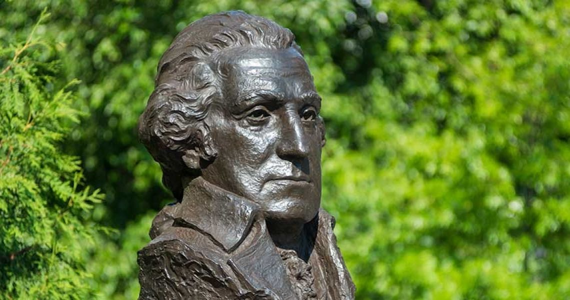 Bust of George Washington in front of green trees