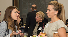 Two women talking to one another at a networking event.