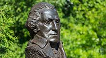 Bust of George Washington in front of green trees