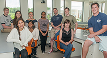 Post Bacc Pre-Med students sitting and standing looking at the camera and smiling