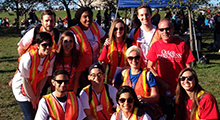 A group of young people wearing orange vests and smiling at the camera.